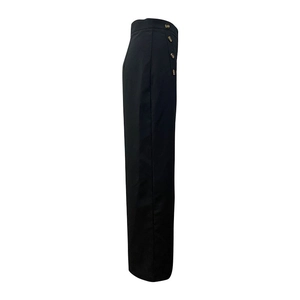 Detail view of high-waisted black wide-leg pants featuring decorative tortoiseshell buttons