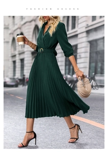 Detail of dark green pleated midi dress with V-neckline and decorative gold buckle belt