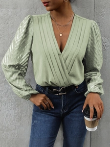 Detail of light green V-neck long sleeve bodysuit with pleated texture and lantern sleeves