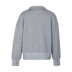 Detail of grey quilted sweatshirt showing wood buttons on sleeves and textured fabric
