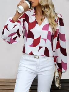 Close-up detail of geometric print blouse with V-neckline and ruffled collar accents