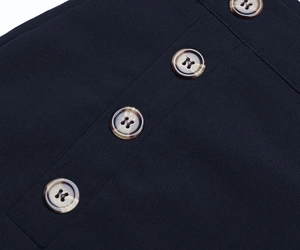 Detail of dark high-waisted wide leg trousers with four tortoiseshell buttons down the front