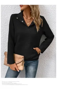 Detail eines schwarzen Langarm-Sweatshirts mit Rautenprägung und dekorativen Metallknöpfen