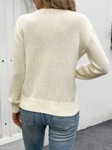 Close-up of ivory knit sweater with fine ribbing detail and classic crewneck texture