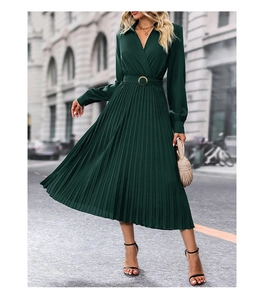 Detailed view of dark green pleated dress featuring a deep V-neck and metallic belt buckle