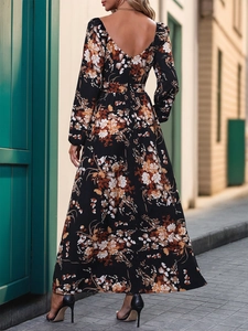 Detail of deep V-neck backless floral maxi dress with orange prints and a cinched waistline