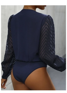 Detail of navy blue ribbed bodysuit featuring sheer mesh sleeves with chevron patterns