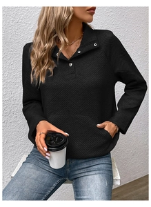 Detail der schwarzen gesteppten Sweatshirt-Struktur mit Rautenmuster und Knopfkragen