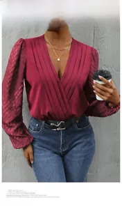 Detail view of burgundy deep V-neck blouse with textured puff sleeves and wrap design