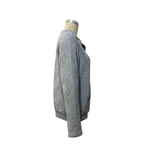 Detailansicht eines hellgrauen Langarm-Sweatshirts mit 3D-Rautensteppung und Textur