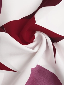 Detail of burgundy and purple geometric abstract print fabric with smooth polyester texture