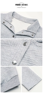 Detailansicht der gesteppten Rautenstruktur und silbernen Druckknöpfe am grauen Sweatshirt