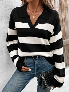 Detail shot of woman wearing a black and white striped polo sweater with a deep V-neckline