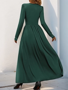 Détail d'une robe longue vert foncé montrant la texture du tissu et les plis à la taille