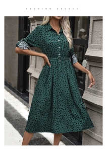 Detail of dark green shirt dress with polka dot print, waist belt and lapel collar