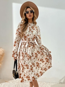 Détail d'une robe fleurie plissée avec col montant à volants et lien à la taille