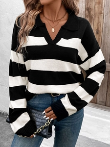 Detail of loose black and white striped knit sweater with polo collar and V-neck opening