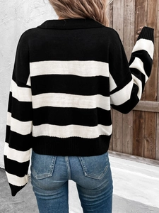 Back view of a loose black and white striped knit sweater with casual blue jeans