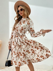 Détail d'une robe fleurie plissée avec col montant volanté et ceinture à nouer rétro