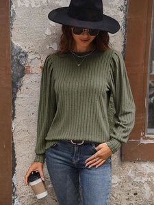 Detail of olive green ribbed knit top featuring pleated puff shoulders and ribbed cuffs