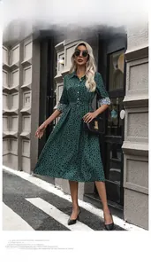 Close-up of dark green polka dot shirt dress with long sleeves and a matching waist belt