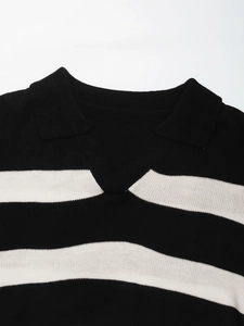 Detailed view of women's knit polo shirt featuring a black and white striped V-neck collar