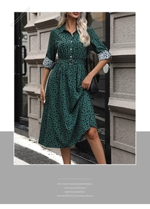 Detail of dark green polka dot shirt dress featuring white buttons and matching waist belt