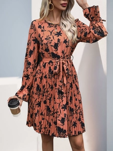 Close-up of floral pleated dress featuring a belted waist and ruffled elastic cuffs