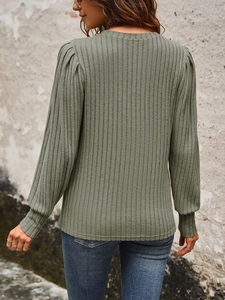 Detail of sage green ribbed knit top showing back fit and subtle puff sleeve design