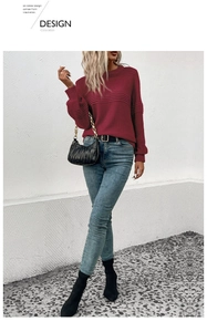 Detail of dark red knit sweater showing ribbed texture on sleeves and elegant crew neck