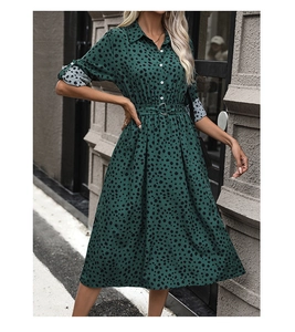 Detail of dark green polka dot dress with shirt collar, waist belt, and cuffed sleeves