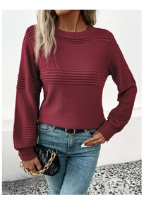 Detail of burgundy crewneck knit sweater featuring parallel ribbed texture and chic metal chain bag