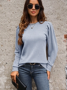 Close-up of light blue ribbed knit texture and stylish puff sleeves on long sleeve top