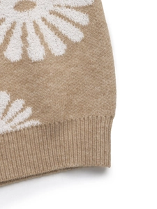 Close-up of khaki floral knit sweater featuring white daisy patterns and ribbed hem detail