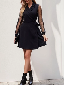 Detail of sheer mesh sleeves with polka dots on a black wrap blazer dress