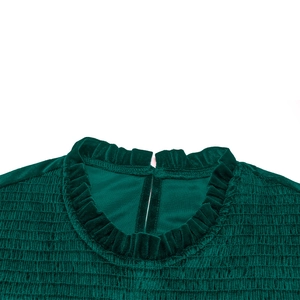 Dettaglio dell'abito in velluto verde scuro con scollo a balze e texture elastica smock