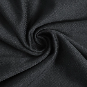 Détail du tissu noir tissé montrant la texture lisse et le drapé élégant de la robe