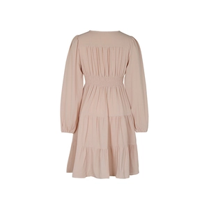 Detail of light pink tiered dress featuring elastic high waist and smocked back details