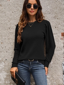 Detail of black ribbed knit top with puff shoulders and classic crew neck for women
