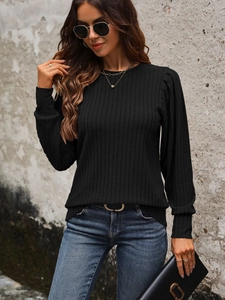 Close-up of black ribbed knit top featuring round neck and subtle puff sleeve details