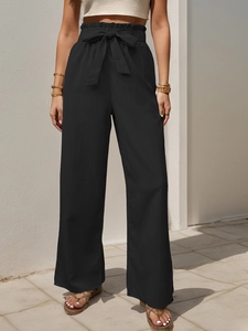 Detail of high waisted wide leg black pants with tie waist and pleated ruffle edge