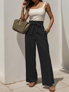 Close-up of paperbag high waist with adjustable tie belt and side pockets on black trousers