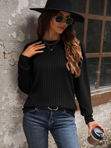 Detail of black rib-knit fabric texture and crew neck design on long sleeve sweater