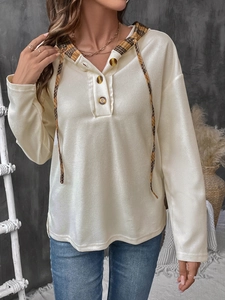 Detail of waffle-knit hoodie with plaid hood lining, drawstring, and button neck