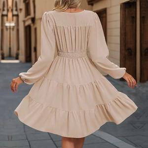 Elegant beige long sleeve tiered dress with cinched waist and pleated skirt