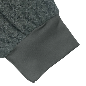 Détail macro de la dentelle florale gris foncé et des poignets en maille côtelée pour femme