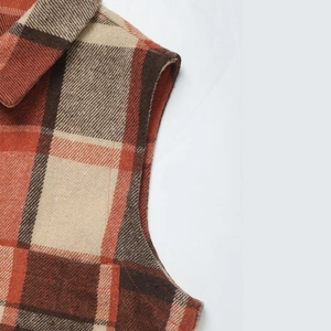 Detail of vintage orange plaid vest featuring thick wool texture and red stitching accents