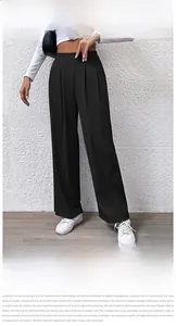 Detail view of black high waisted wide leg knit trousers with pleated waist design
