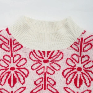 Detail of white ribbed mock neck knitwear with red floral jacquard pattern