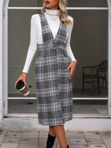 Detail of grey plaid overall dress with vintage buttons and white turtleneck sweater